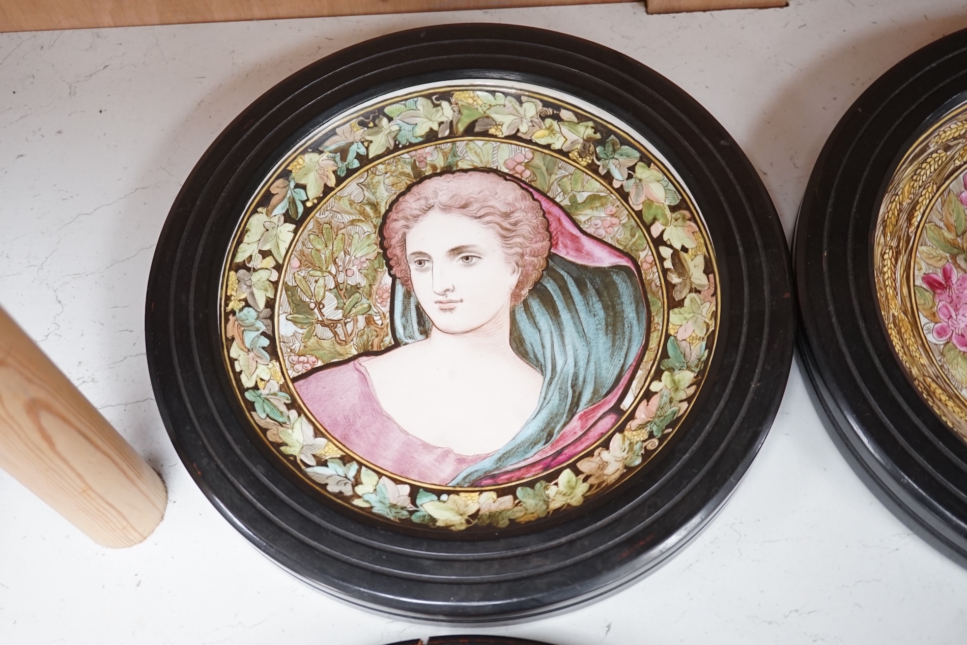 A set of four Copeland Spode Aesthetic period, outside decorated four seasons portrait plates, circa 1880, housed in ebonised wood frames, overall 31cm in diameter. Condition - fair, three frames cracked